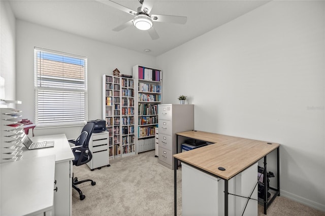 office featuring baseboards, light carpet, and ceiling fan