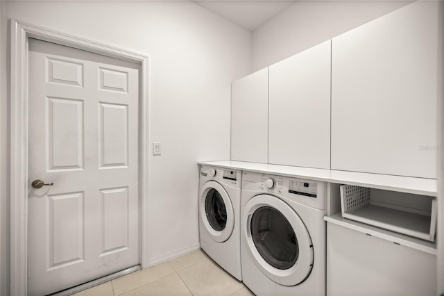 laundry room featuring light tile patterned floors, baseboards, cabinet space, and independent washer and dryer