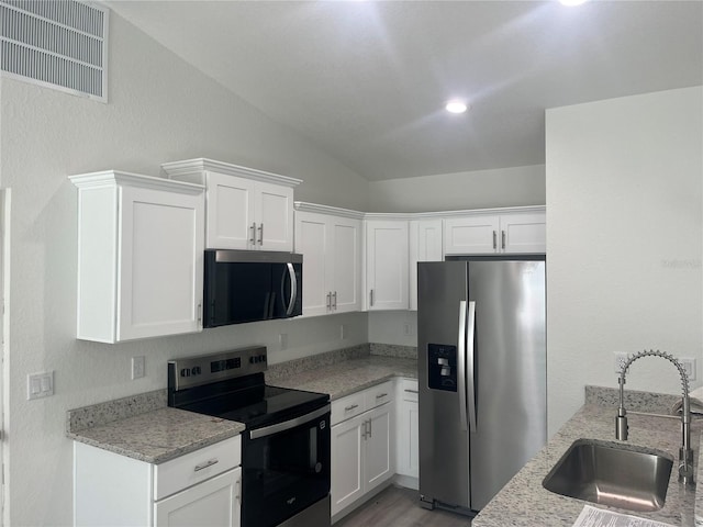 kitchen featuring visible vents, a sink, white cabinetry, appliances with stainless steel finishes, and light stone countertops