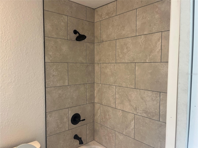 interior details featuring washtub / shower combination