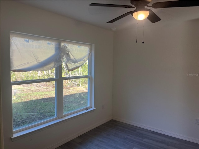 empty room featuring dark wood-style floors and baseboards