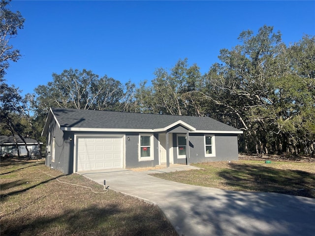 single story home with stucco siding, a front lawn, driveway, roof with shingles, and an attached garage