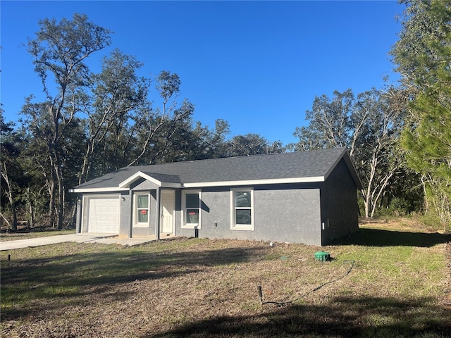 ranch-style home with a front yard, an attached garage, driveway, and stucco siding