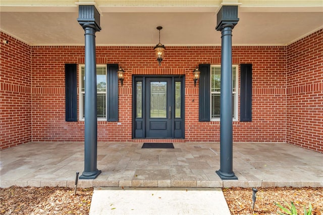 doorway to property with brick siding