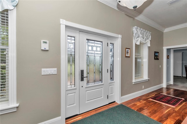 foyer entrance featuring visible vents, wood finished floors, baseboards, and ornamental molding