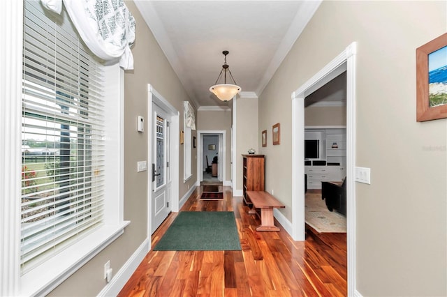 entrance foyer with crown molding, wood finished floors, and baseboards