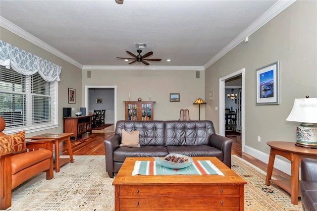 living room featuring light wood-type flooring, baseboards, visible vents, and crown molding