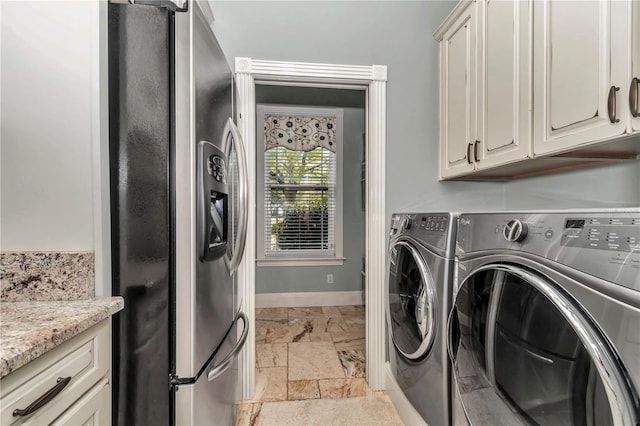 laundry room featuring washer and dryer, baseboards, and stone tile floors