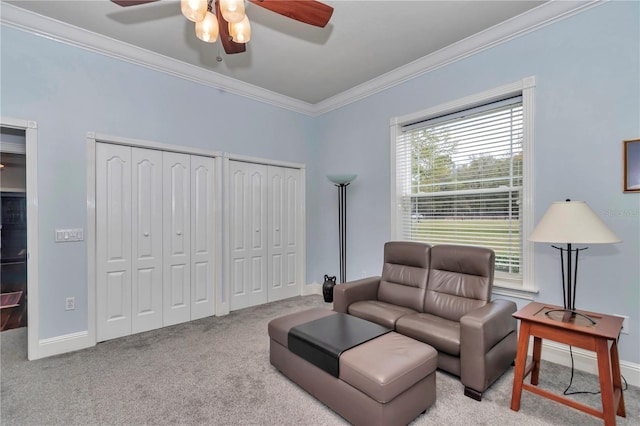 living area with carpet flooring, ceiling fan, crown molding, and baseboards