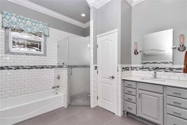 bathroom with tile walls, ornamental molding, vanity, and tile patterned flooring