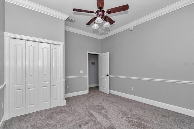 unfurnished bedroom featuring carpet, baseboards, visible vents, a closet, and crown molding