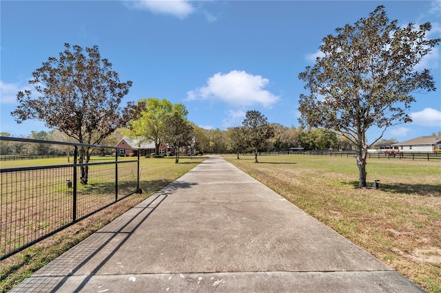 view of road featuring concrete driveway and a rural view