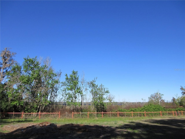 view of yard featuring a rural view and fence