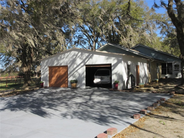 garage with driveway and fence