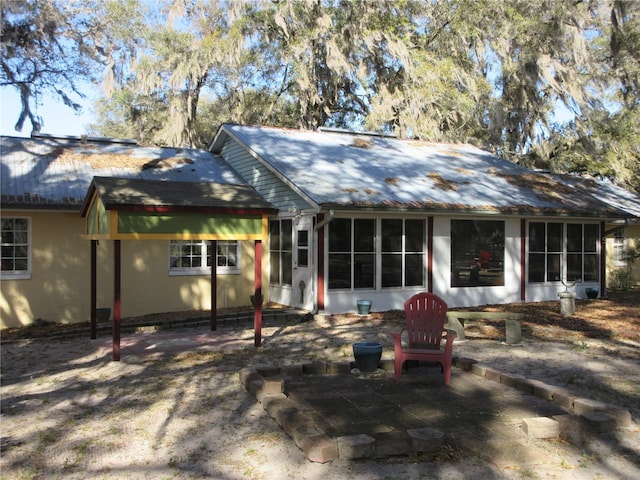 rear view of house with a patio and a sunroom