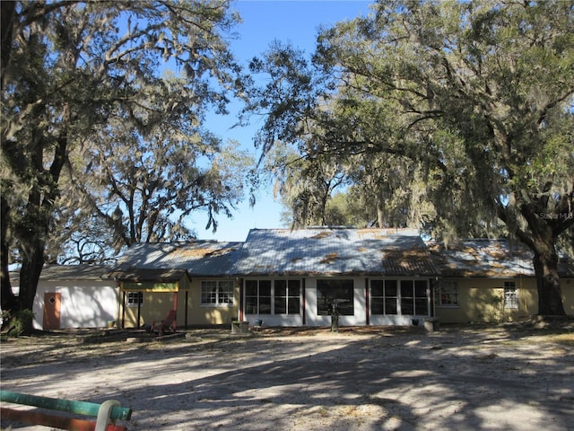 ranch-style home with a garage and metal roof