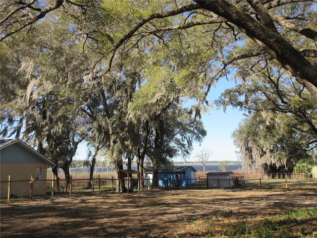 view of yard featuring a rural view and fence