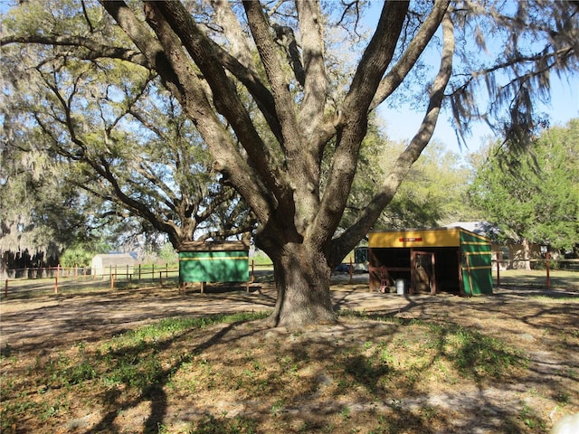 view of yard featuring an outdoor structure and fence