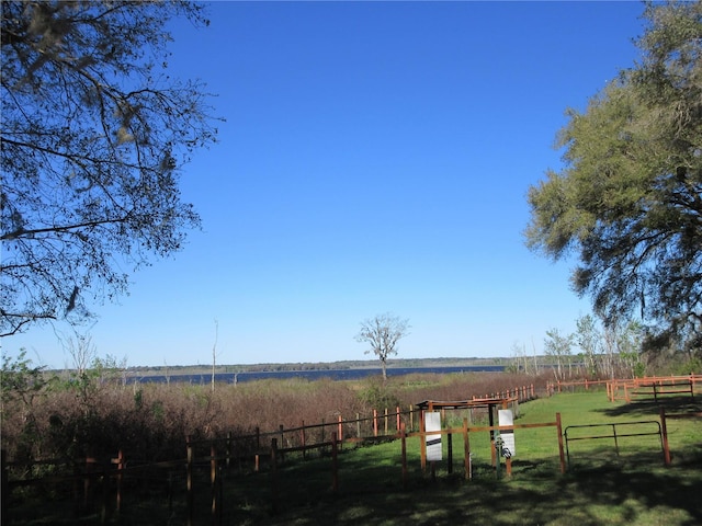 view of yard with a rural view and fence