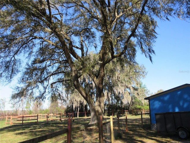 view of yard with a rural view and fence