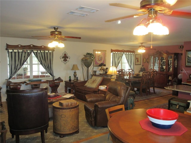 living room featuring visible vents, wood finished floors, and a ceiling fan