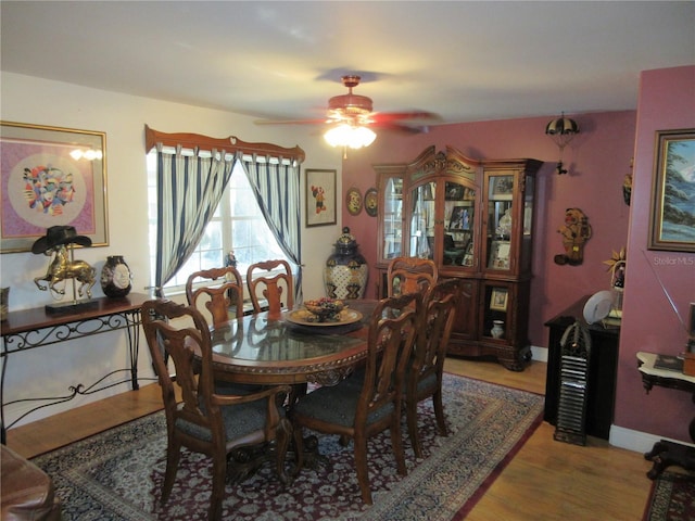 dining space with baseboards, light wood-style floors, and a ceiling fan