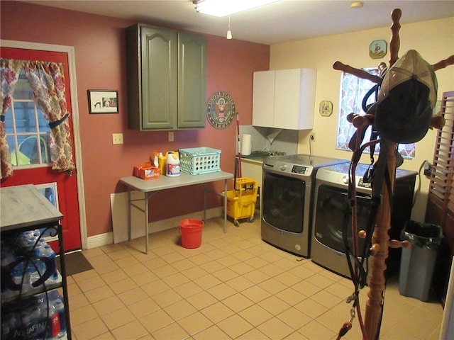 washroom with separate washer and dryer, light tile patterned floors, cabinet space, and baseboards