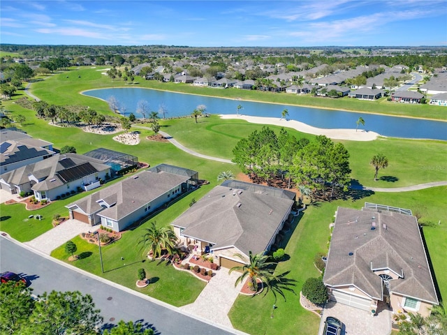 drone / aerial view with golf course view, a residential view, and a water view