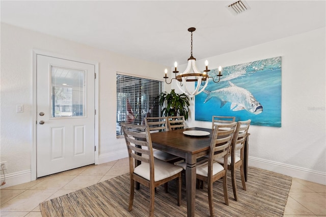 dining room with light tile patterned flooring, baseboards, visible vents, and a chandelier