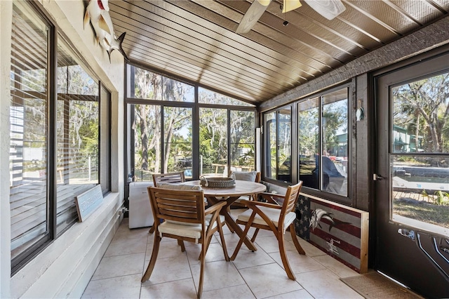 sunroom featuring wood ceiling, a ceiling fan, and vaulted ceiling