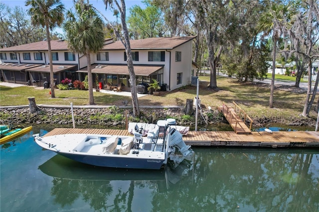 dock area featuring a patio area, a lawn, and a water view