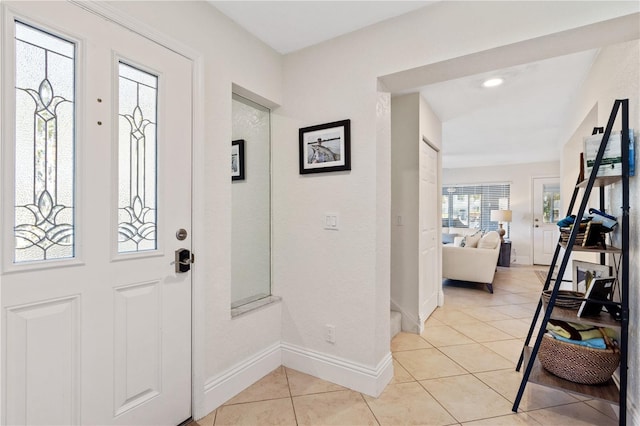 foyer entrance with light tile patterned flooring and baseboards