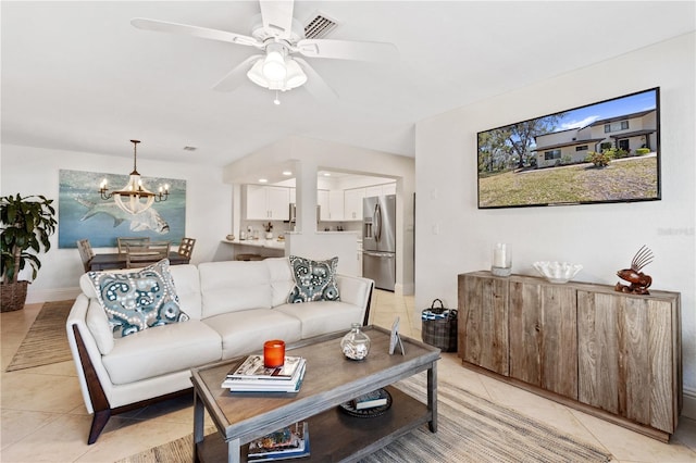 living area featuring light tile patterned floors, visible vents, ceiling fan with notable chandelier, and baseboards