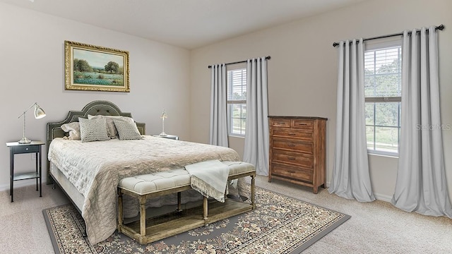 bedroom featuring light colored carpet and baseboards