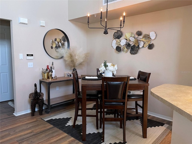 dining area featuring wood finished floors, baseboards, and a chandelier