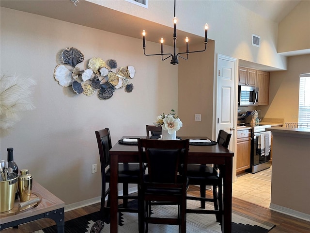 dining room with baseboards, visible vents, a chandelier, and light wood-type flooring