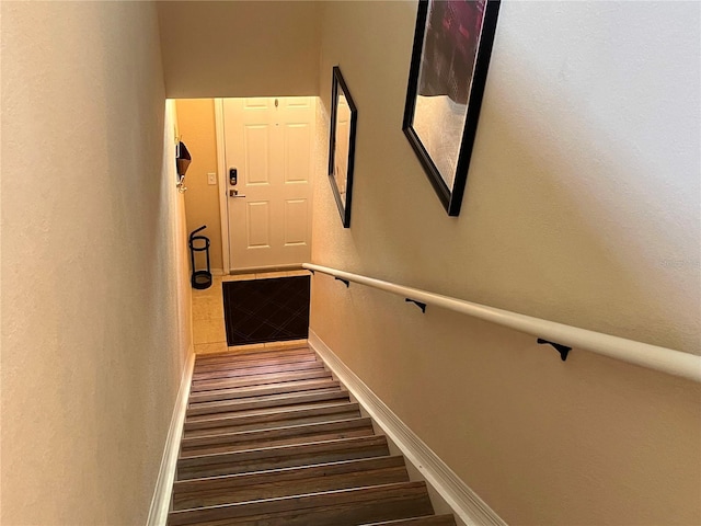 stairway featuring baseboards and wood finished floors