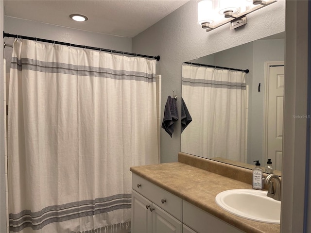 bathroom with vanity and a textured wall