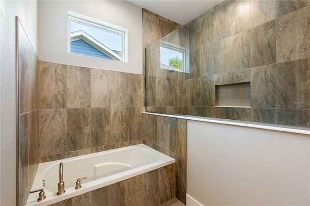 full bathroom featuring tile walls, tiled bath, and walk in shower