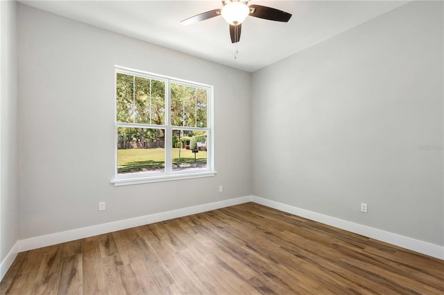 empty room featuring a ceiling fan, baseboards, and wood finished floors