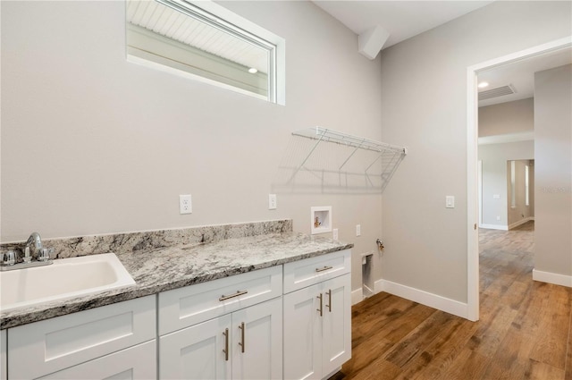 laundry area with light wood-style flooring, a sink, cabinet space, baseboards, and hookup for a washing machine