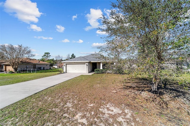 single story home featuring an attached garage, concrete driveway, and a front yard