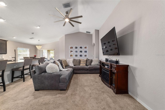 living room featuring baseboards, visible vents, light carpet, and lofted ceiling