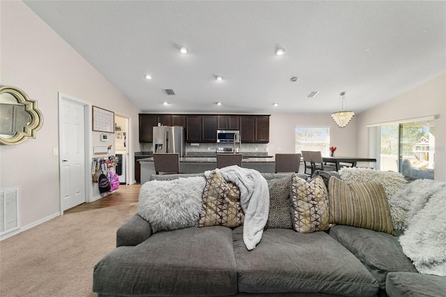 living area with visible vents, light colored carpet, and vaulted ceiling