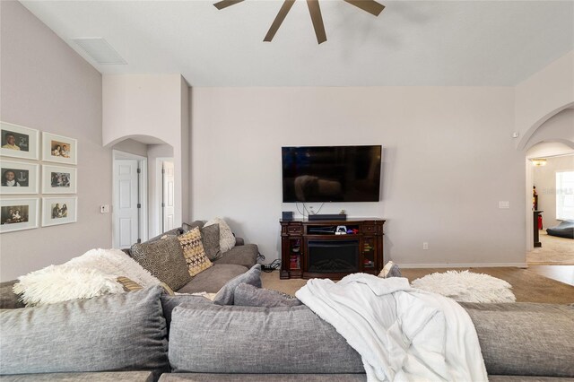 living room featuring carpet flooring, visible vents, and arched walkways