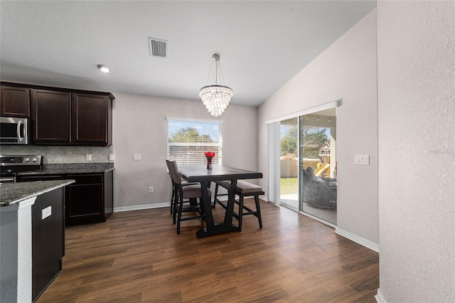 kitchen with tasteful backsplash, visible vents, dark wood-type flooring, vaulted ceiling, and stainless steel appliances