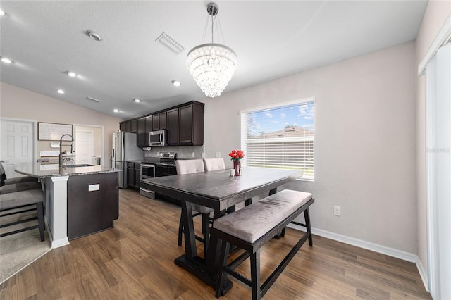 dining space featuring baseboards, visible vents, lofted ceiling, dark wood-style flooring, and a notable chandelier