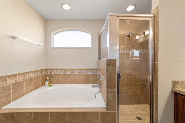 full bathroom with vanity, a shower stall, and a garden tub