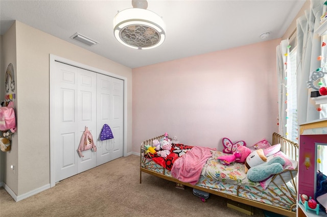 carpeted bedroom featuring baseboards, visible vents, and a closet