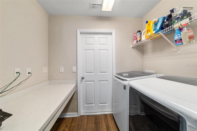 laundry area with visible vents, dark wood-type flooring, laundry area, a textured ceiling, and separate washer and dryer